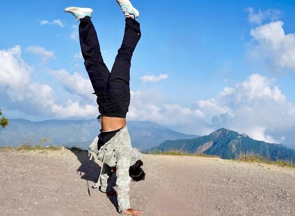 Person doing a handstand on a mountain path